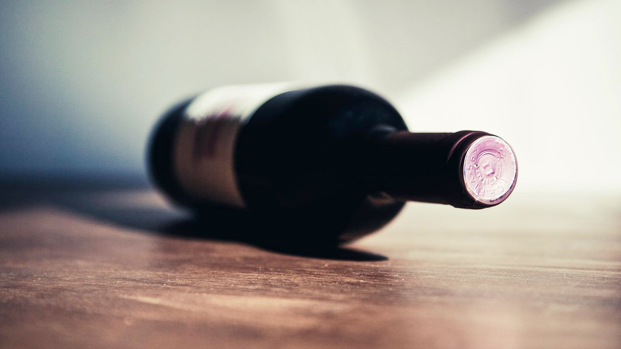 Leżąca butelka wina z widocznym korkiem – przechowywanie i dojrzewanie wina